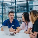 three staff members talking in a hospital setting
