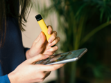 Person holding vape and phone