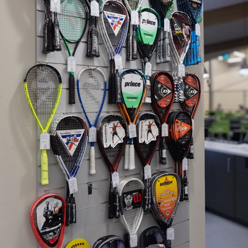 Squash racquets for sale hanging on a wall