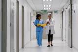 a nurse and a doctor walking through a hospital corridor