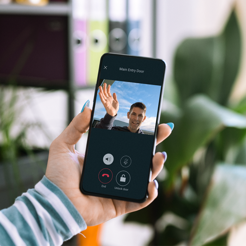 Woman holding phone with a man waving