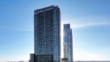 Image of The MET condo tower in Vaughan, Ontario against a blue sky background